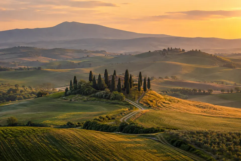 Colline della Val d'Orcia con cipressi al tramonto